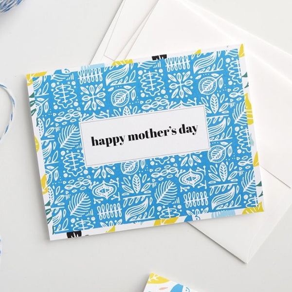 A vibrant blue patterned happy mothers day card idea with white text.