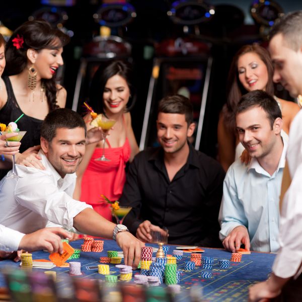 Friends gathered around a casino table playing games at an adult birthday party.