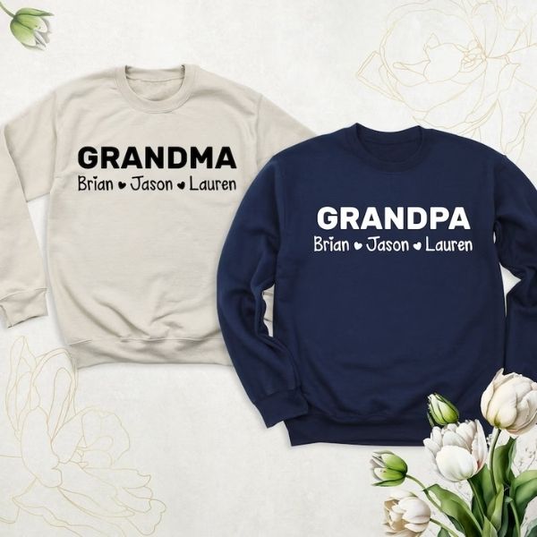Beige and navy sweatshirts with 'GRANDMA' and 'GRANDPA' text, personalized with grandkids' names for Grandparents Day.