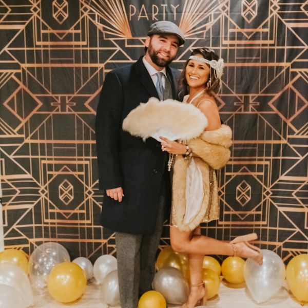 Couple dressed in vintage attire at a Gatsby-themed adult birthday party.