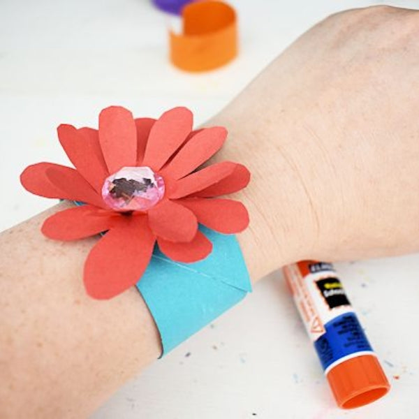 A handmade flower bracelet adorning a wrist, paired with a mother's day card.