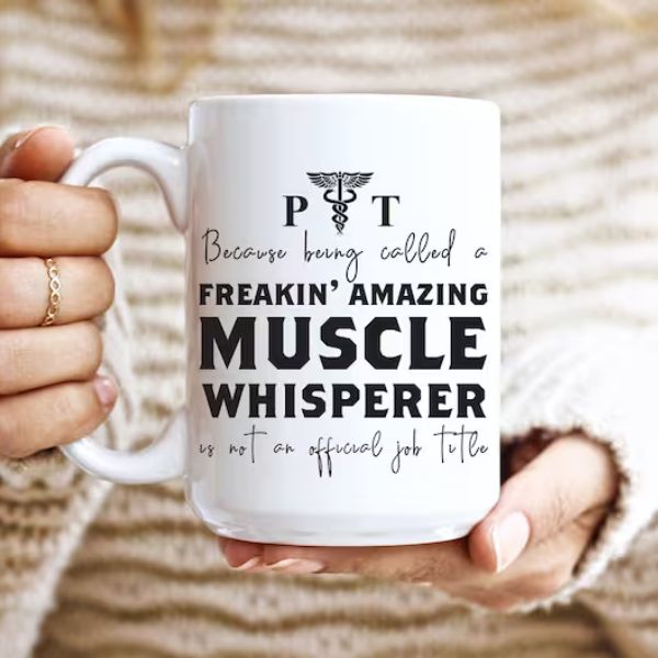 Freakin' Amazing Muscle Whisperer Mug is a flattering and funny gift for physical therapists, celebrating their skillset.