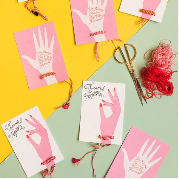 A mother's day card idea featuring a cutout hand with an attached friendship bracelet