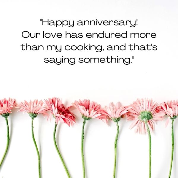 Delicate pink flowers lined up with a humorous anniversary message that celebrates enduring love and cooking.