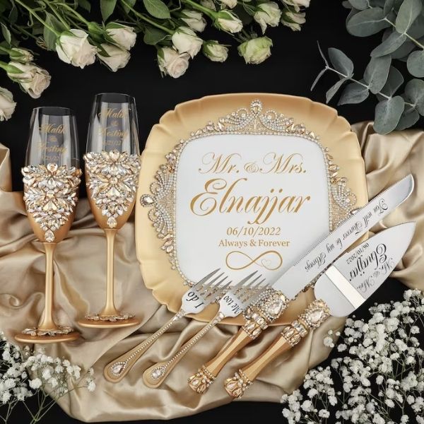 Gold Champagne Glasses paired with Cake Knives are exquisite 50th anniversary gifts for a golden celebration.
