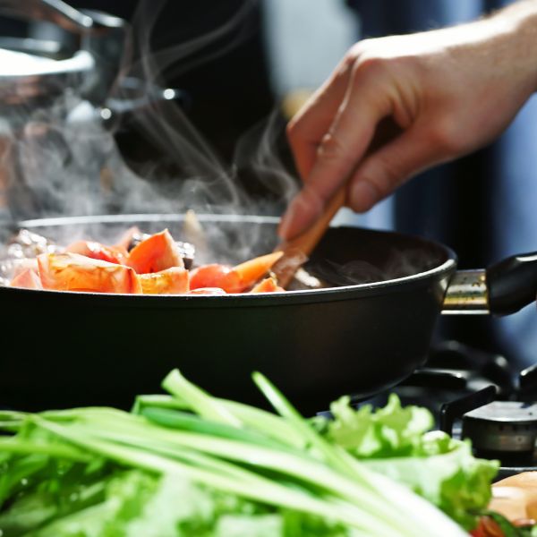 Hand stirring a gourmet dish during a cooking challenge.