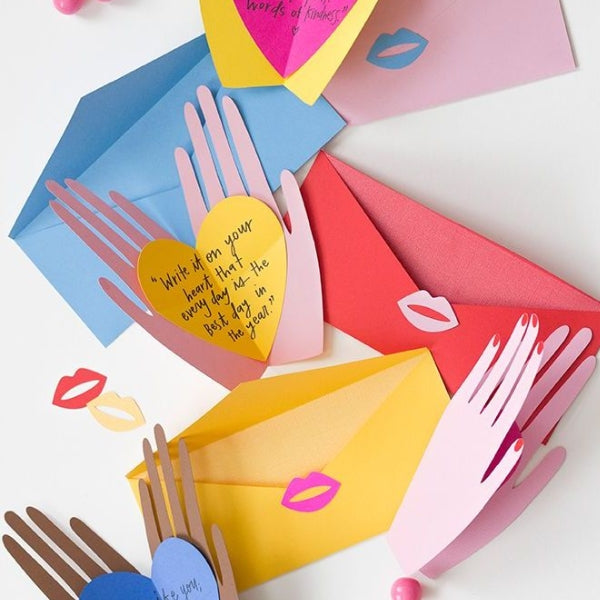 A silhouette of a hand holding a heart shape on a mother's day card.