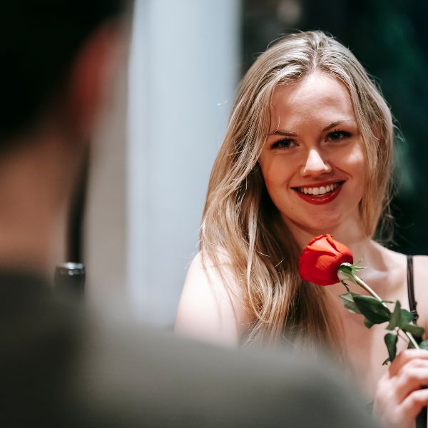 The image of a woman, graced with a genuine smile, accepting a single red rose, captures the essence of such a 3 Year Anniversary occasion.