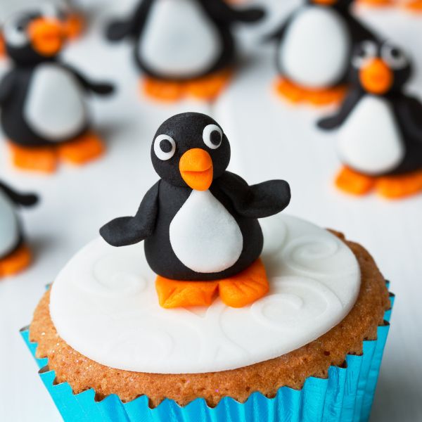 An adorable penguin-shaped cupcake decorated with frosted details,