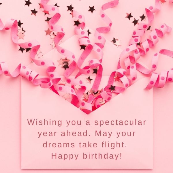 Birthday card with pink streamers and confetti forming a heart, wishing a spectacular year ahead.