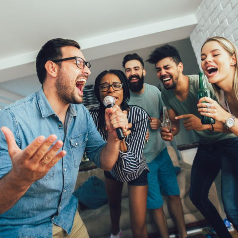 Group of friends enjoying a karaoke party at home.