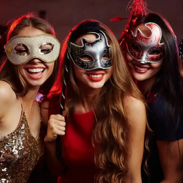 Guests wearing ornate masks at a masquerade ball-themed adult birthday party.