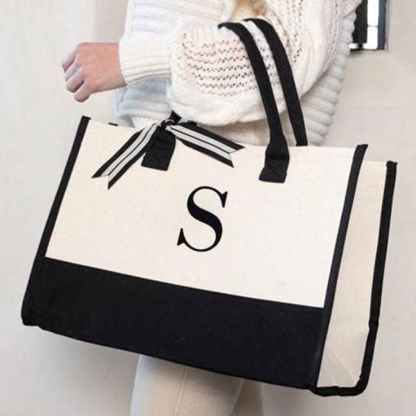 Carry essentials in style with Mud Pie's classic black and white initial canvas tote bags.