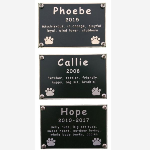 Customized engraved plates for pet memorials, each with a unique name and message