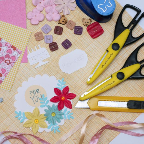 Crafting tools and decorations spread out for a scrapbooking activity