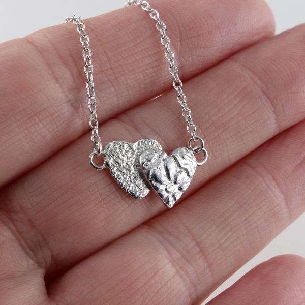 A gleaming silver heart necklace, delicately adorned, serving as an exquisite token of love and friendship