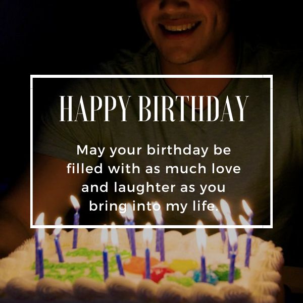 Man smiling with birthday cake and lit candles, heartwarming birthday greeting on image.