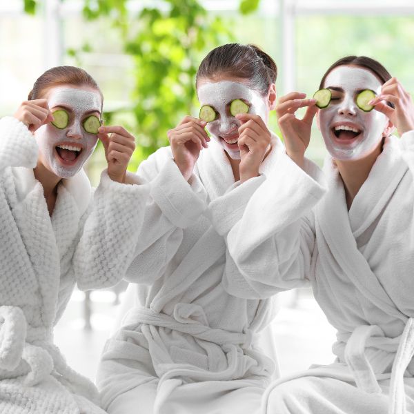 Friends enjoying a spa day with facial treatments and laughter.