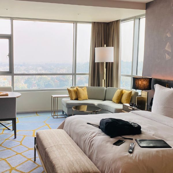 Modern hotel room interior with large windows and city view.