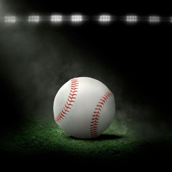 A spotlighted baseball on a field evoking the thrill of sports-themed adult birthday parties.