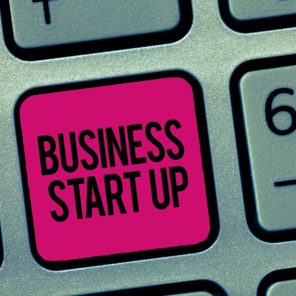 A close-up of a bold pink 'BUSINESS START UP' key on a keyboard symbolizing the beginning of a new venture and the digital steps towards entrepreneurial success.