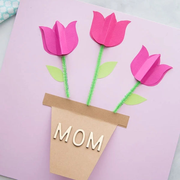 A mother's day card featuring bright pink tulip cutouts in a paper pot.