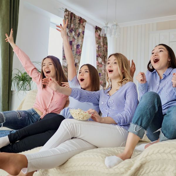 Friends laughing joyously at a virtual movie watching party.