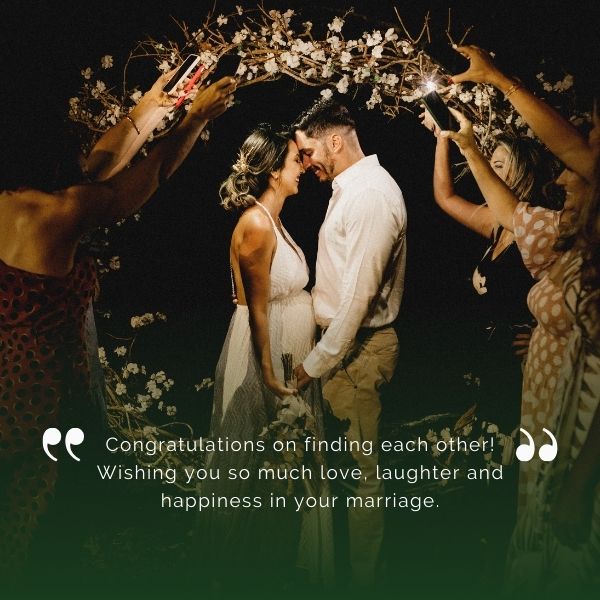 Couple being celebrated by friends under a floral arch with a wedding quote wishing love, laughter, and happiness in marriage.