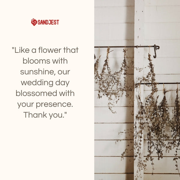 Rustic dried flowers hanging on a wall, with a SANDJEST wedding thank you note.
