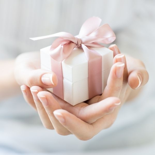 Hands holding a small gift box, representing the thoughtfulness behind an 8 year relationship gift.