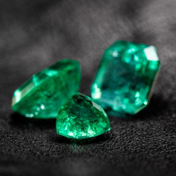 Three vibrant emeralds representing the traditional gift for a 20th anniversary.