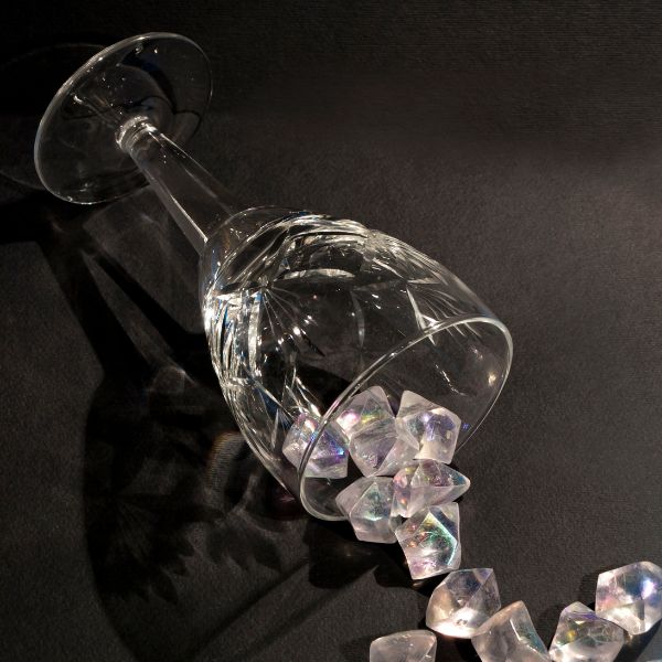 Crystal wine glass with jewels cascading out, symbolizing the 'Crystal' theme for a 15th wedding anniversary.