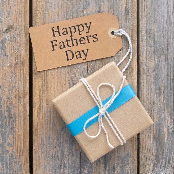 A beautifully wrapped gift with a Happy Father's Day tag on a wooden surface