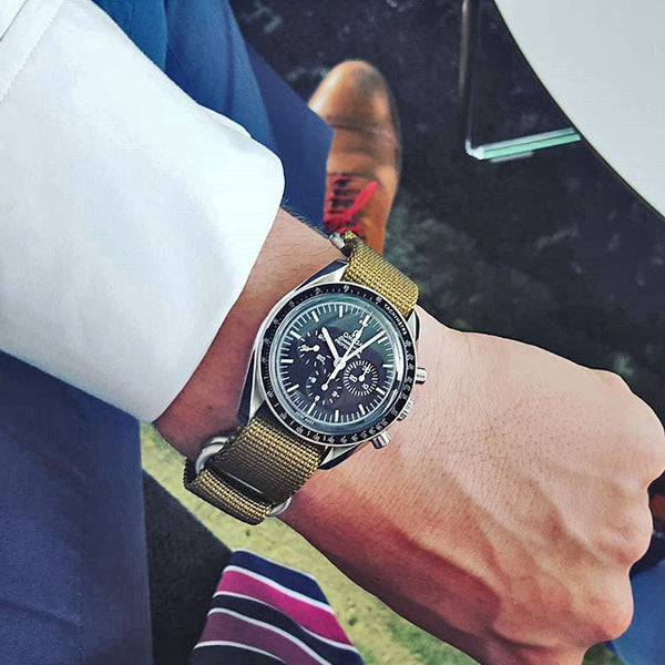 olive nylon watch strap on an omega speedmaster pro watch