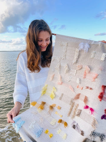 Lucie holding a weaving she made