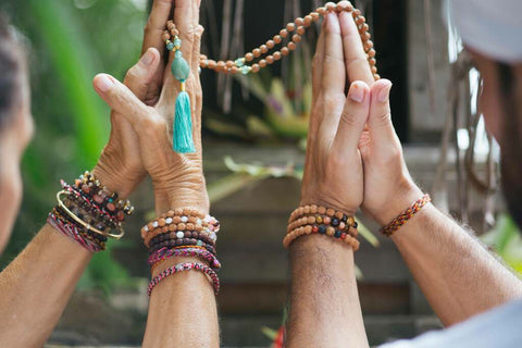 hands blessing a bali mala with amazonite and rudraksha prayer beads
