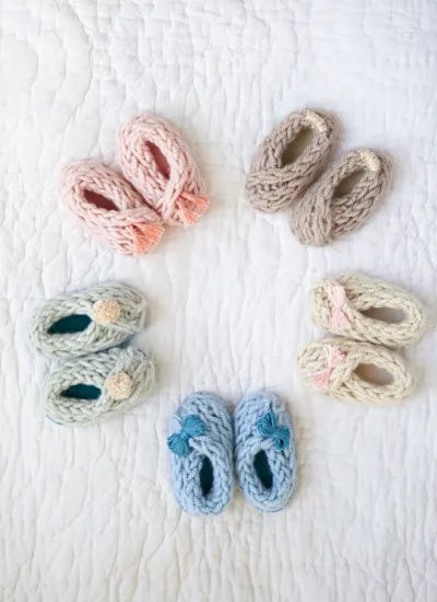 knitted baby booties arranged in a circle in soft colors