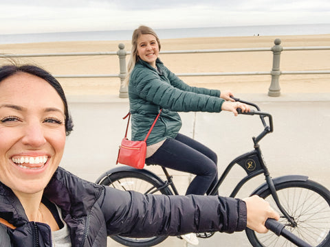 two girls bike riding on beach