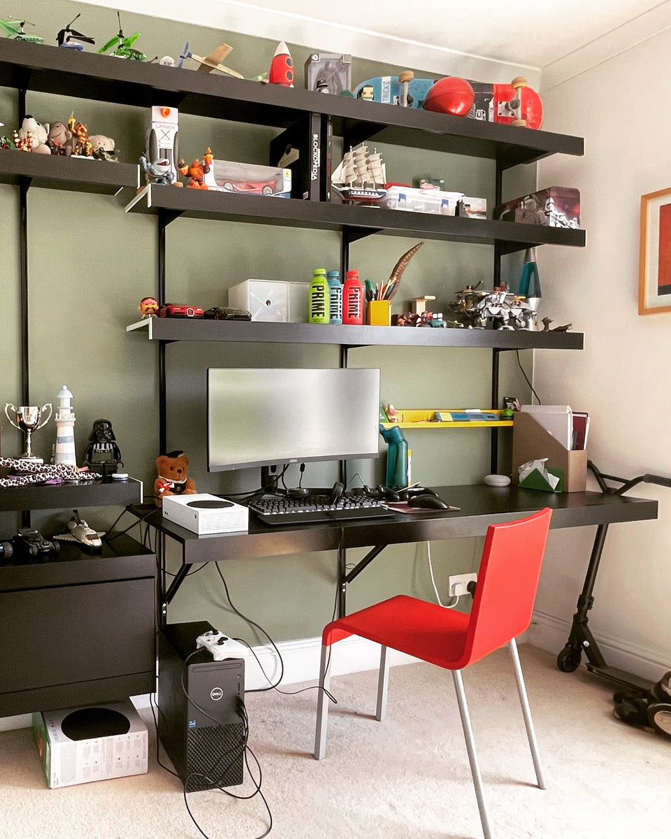 Black shelving system with floating wall desk