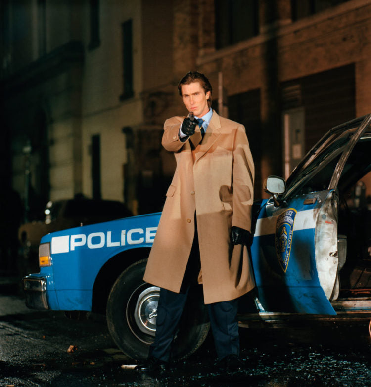 camel coat in american psycho about christian bale brandishing a gun