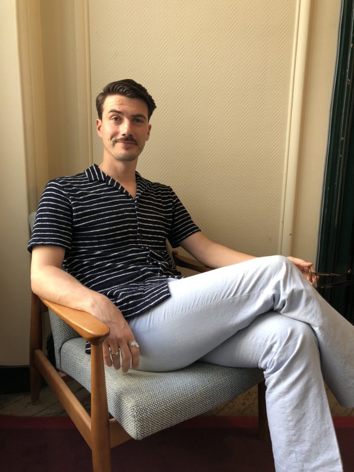 man sitting striped short-sleeved shirt sky blue pants