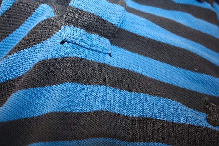 Blue and black striped polo shirt - focus angles of the buttonhole placket