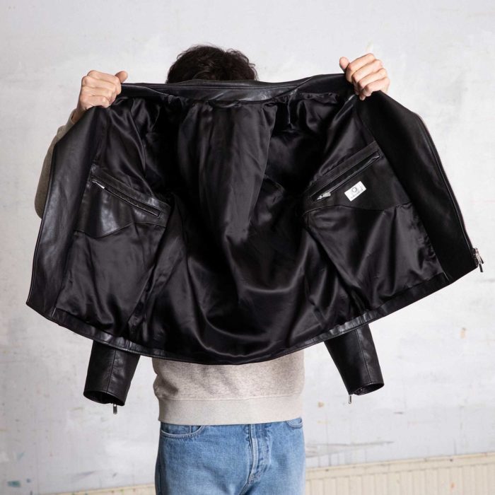 Man holding an open black perfecto.