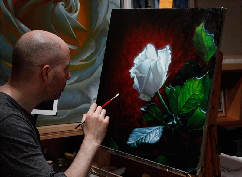 Vincent Keeling painting a white rose, with red background