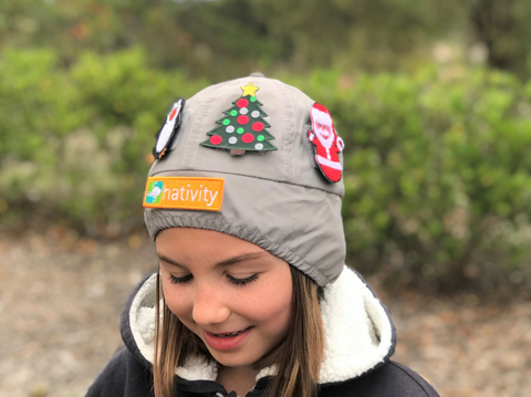 Child wearing hativity bennie near camping area in the grey color