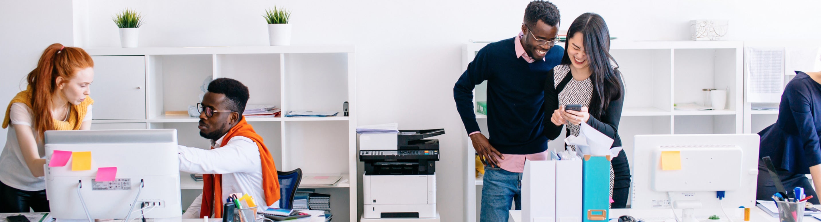 Modern office scene: Employees discussing documents with printer in background