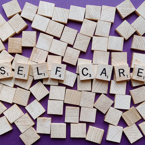 Self care spelled in Scrabble pieces