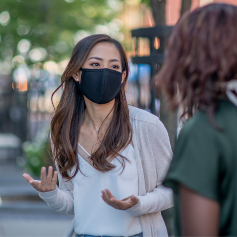 Masked woman meeting friend social distanced