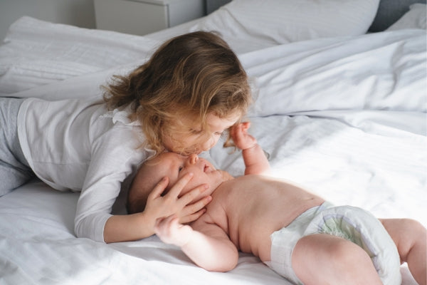 Big sister kissing baby