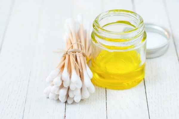 jar of oil and Q tips